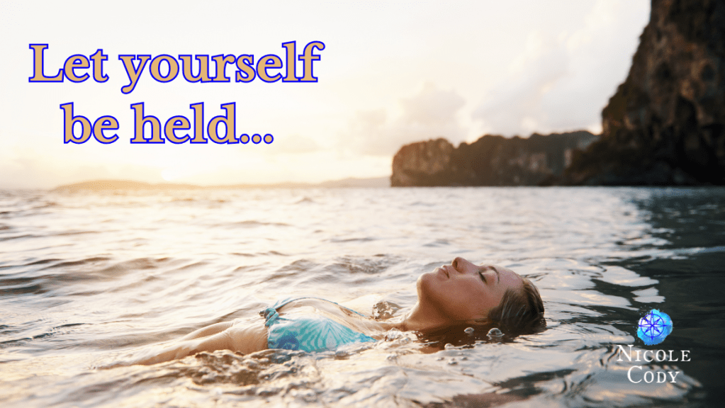 Woman floating peacefully in ocean water at sunset.